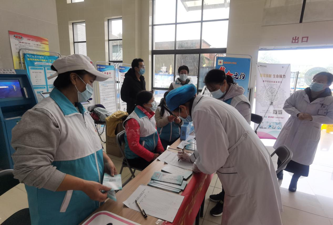 志愿者为前来报名登记遗体器官捐献志愿者的市民、医护人员介绍登记流程并送去宣传品2.png